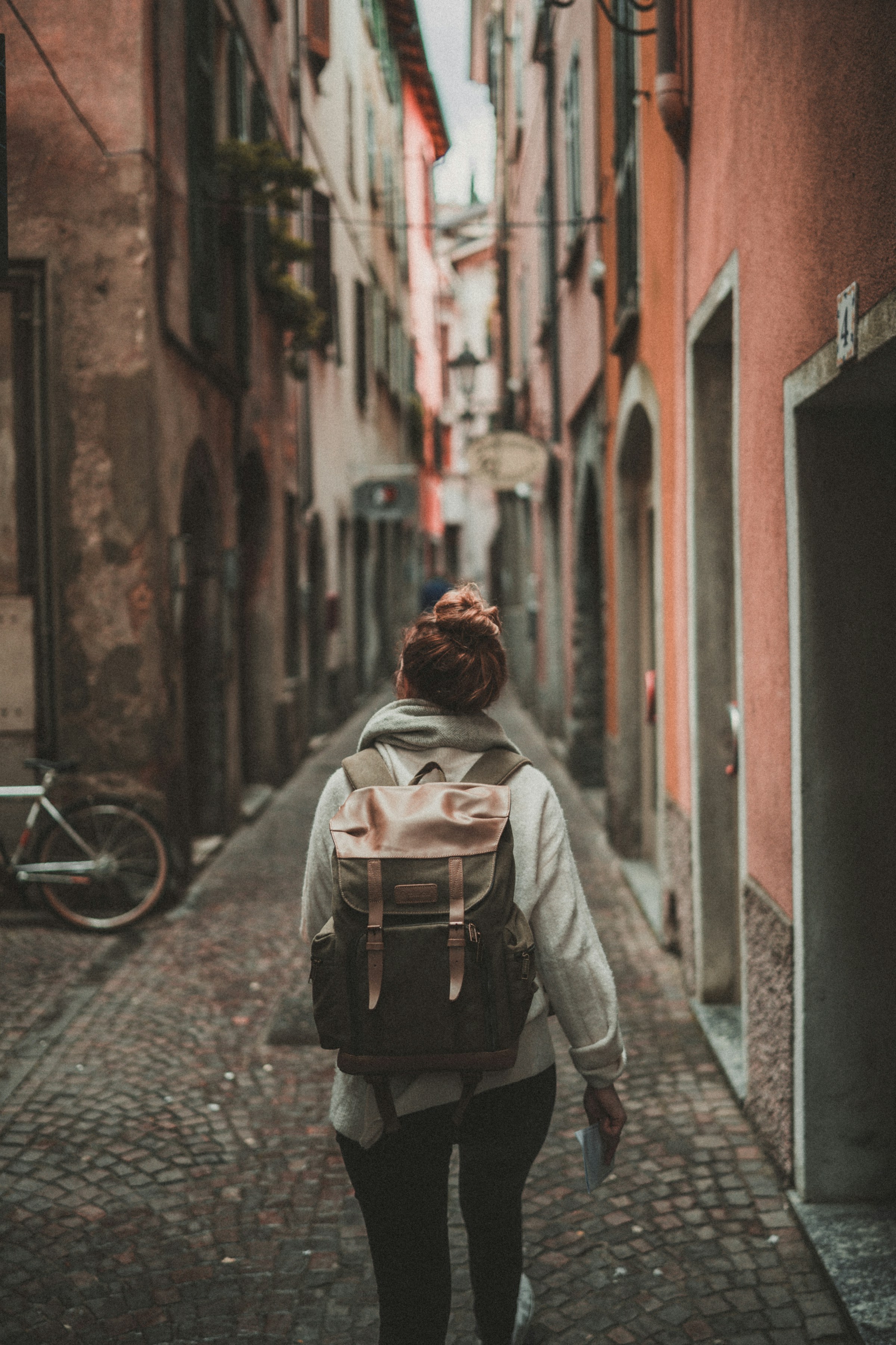 Traveler with a backpack wandering a warm old-town alley